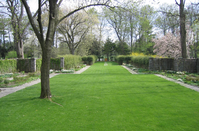 A manicured grass lawn flows through the center of the formal walled gardens and paths.