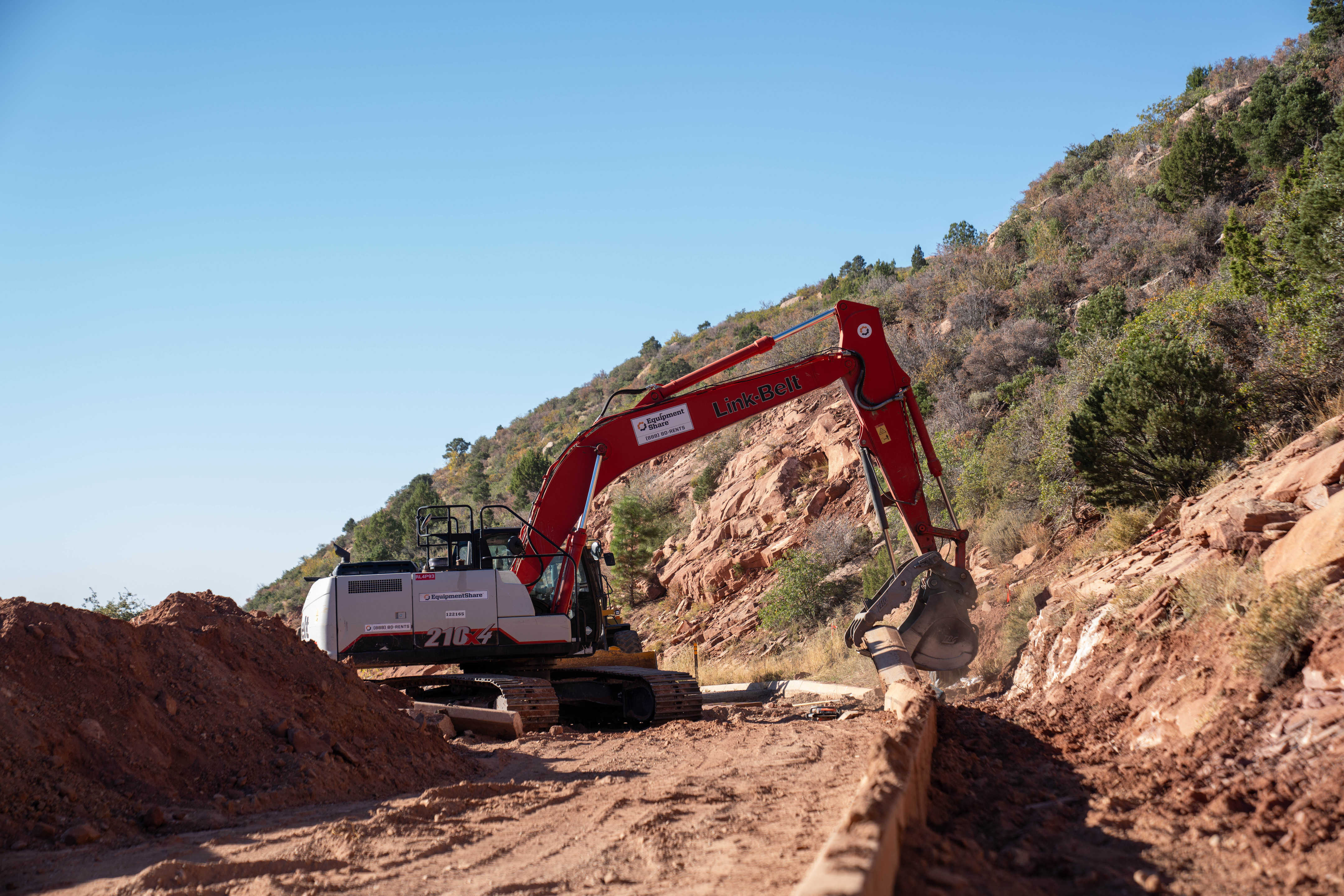 A construction vehicle removing the curb with a large claw
