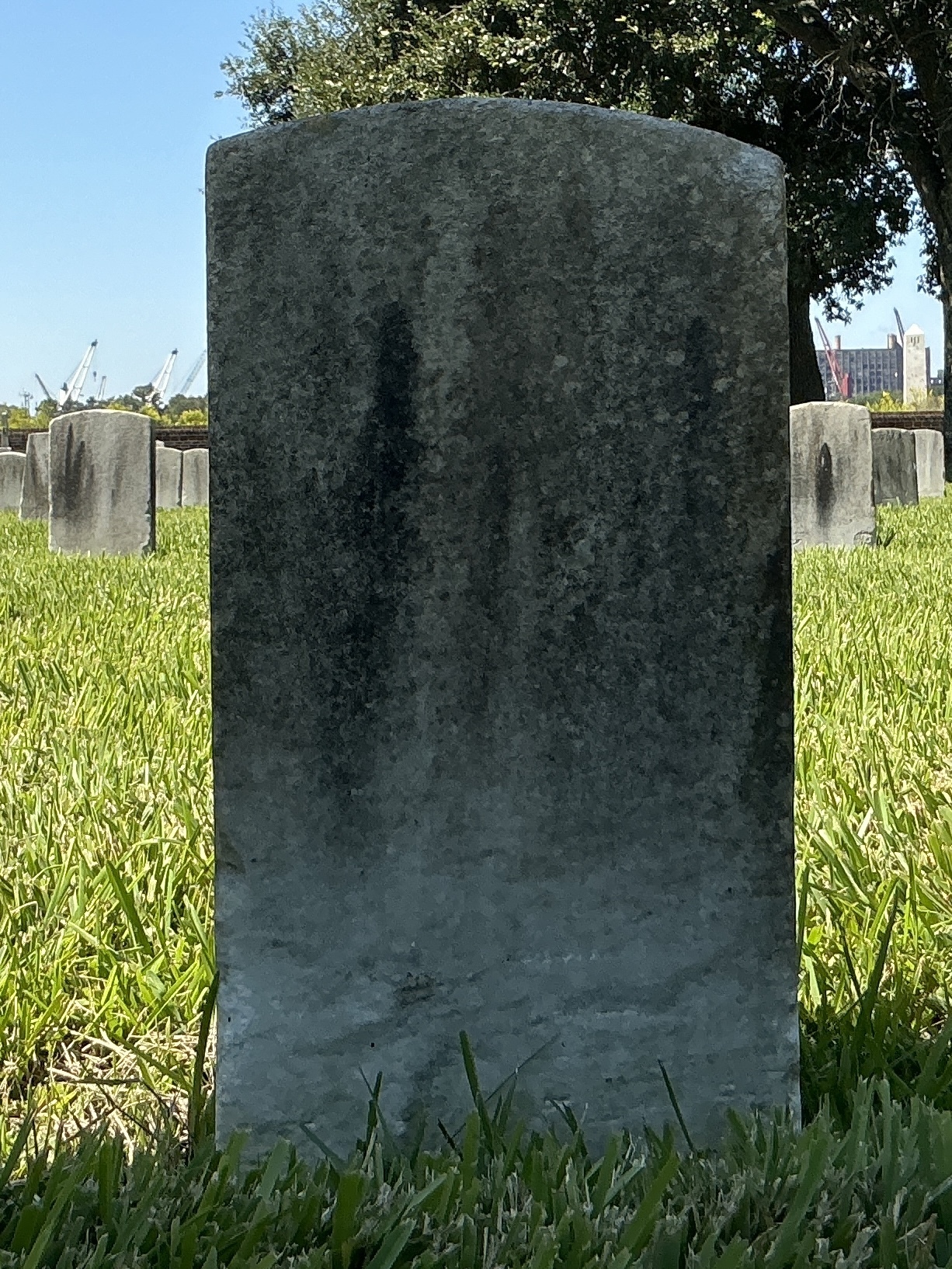 Back of historic upright marble headstone with recessed shield face.