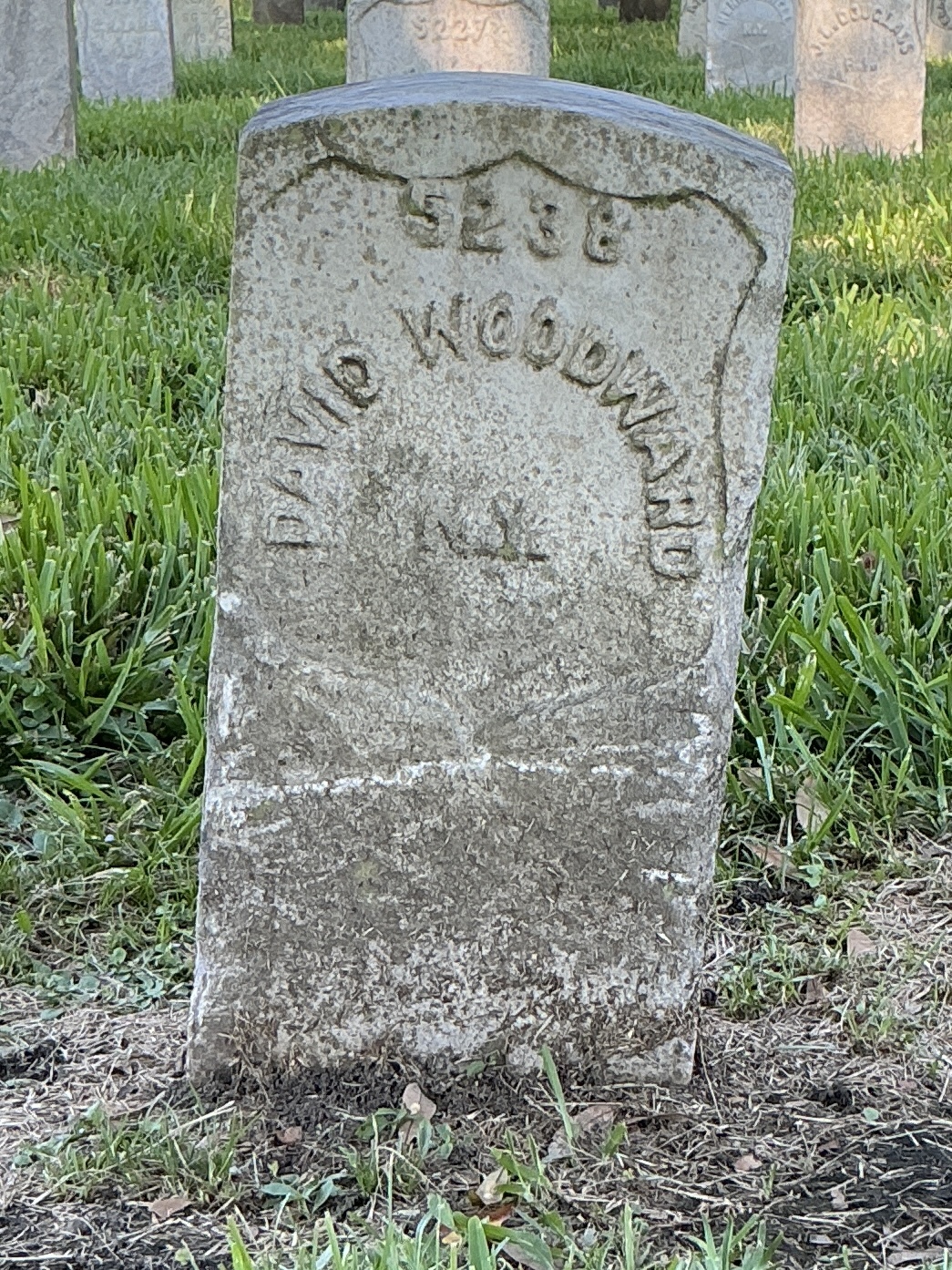 Front of historic upright marble headstone with recessed shield face.
