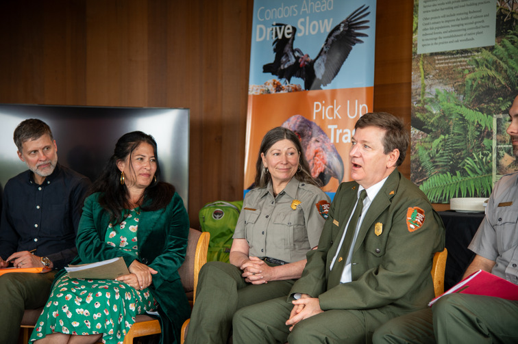 A group of 4 people, including Ada Limón, listening to Superintendent Steve Mietz speak.