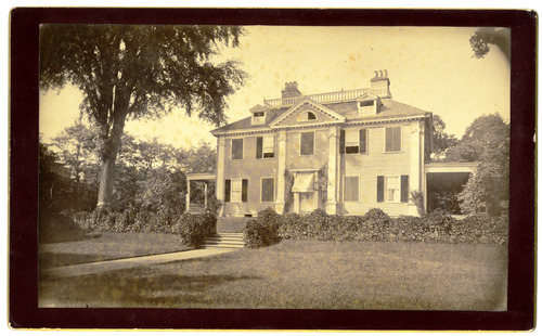 Black and white photograph of front elevation of Georgian house with lawn in front