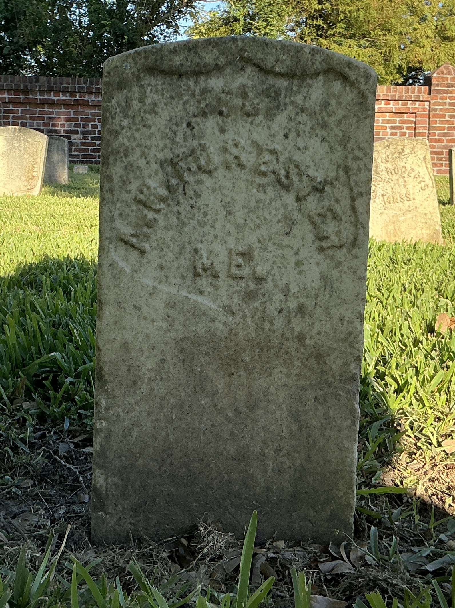 Front of historic upright marble headstone with recessed shield face.