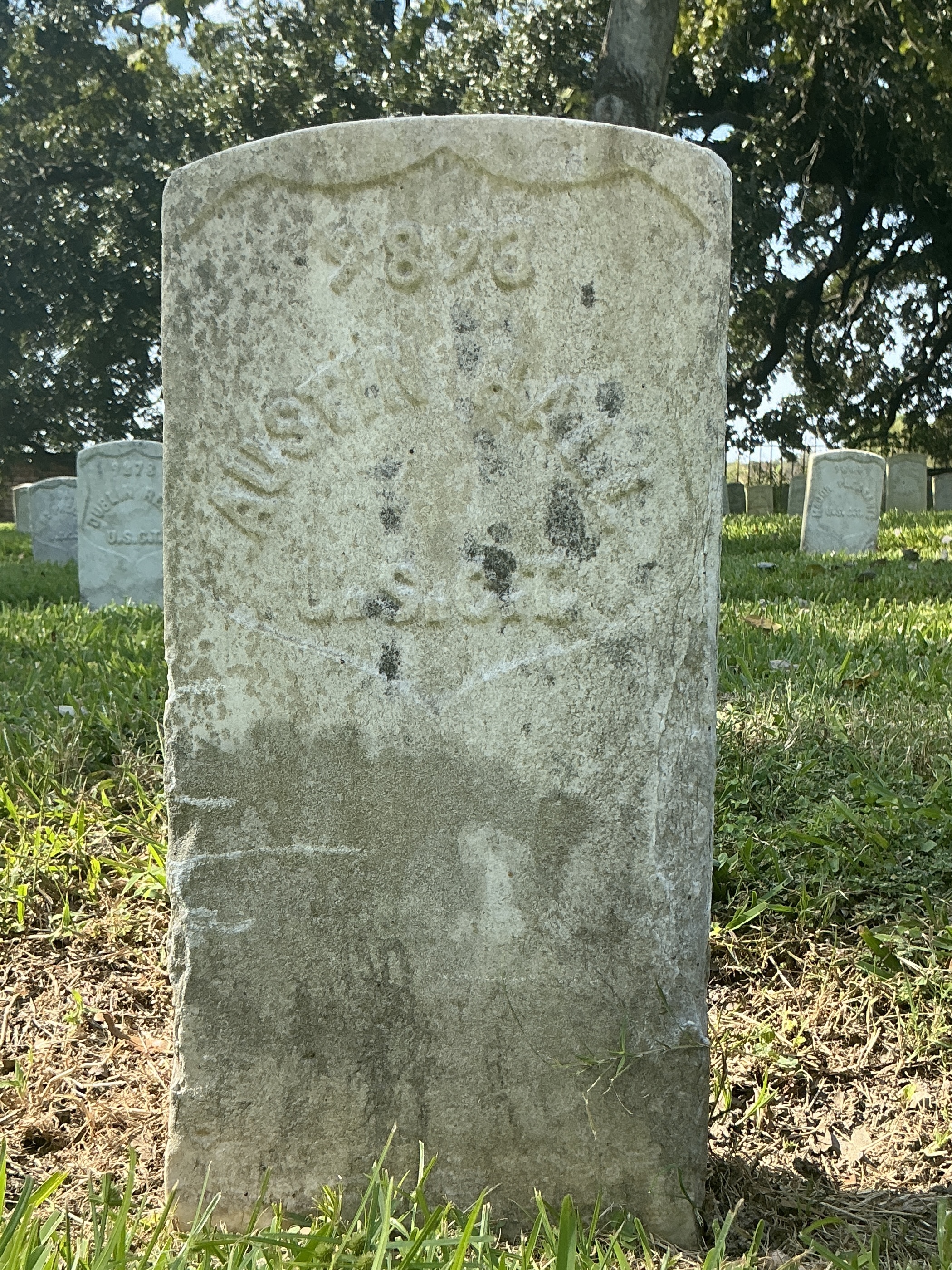 Front of historic upright marble headstone with recessed shield face.