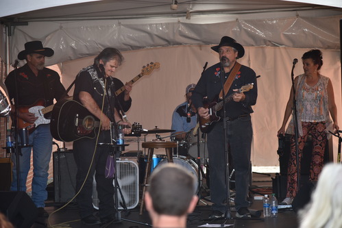 A group of 5 band members performing on a stage