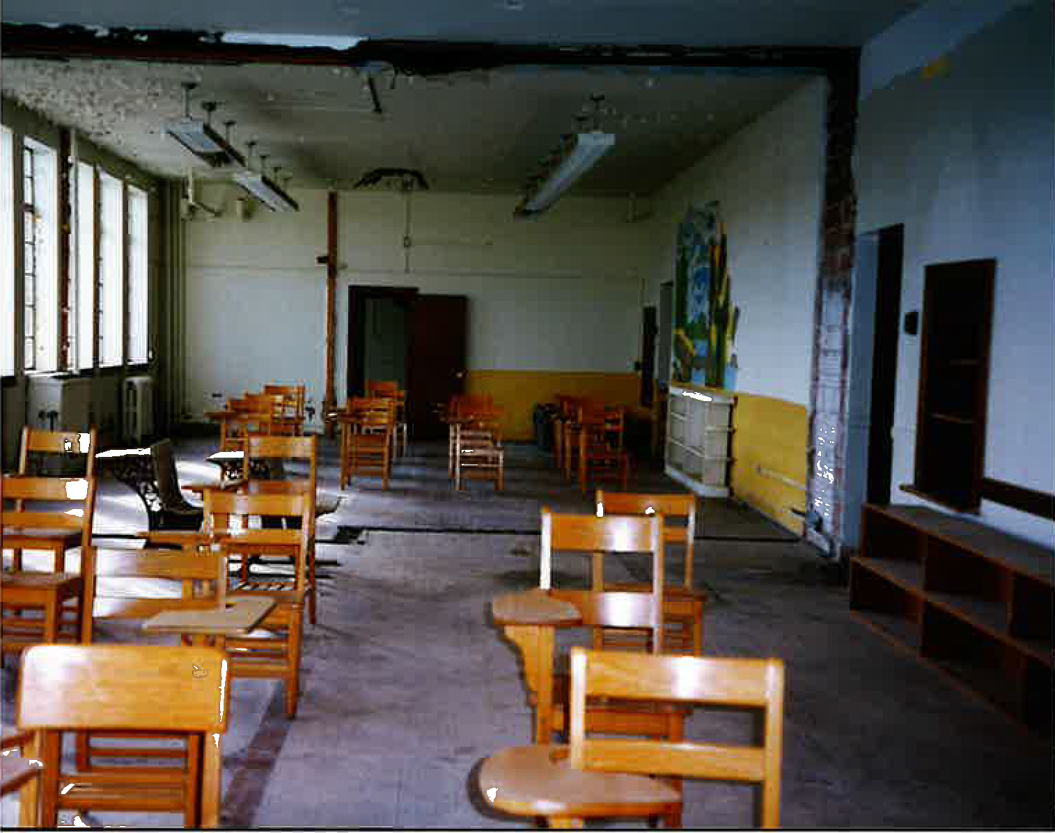 classroom devoid of everything but wooden desks