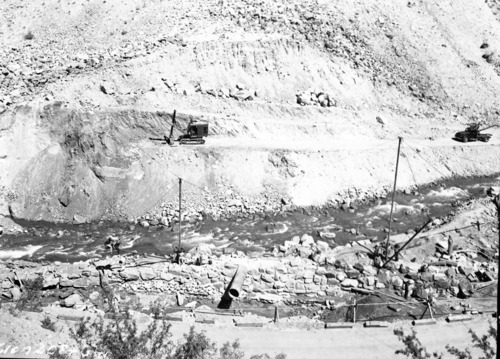 Damaged tractor/trailer truck in Oak Creek maintenance area. Damage caused by rock fall boulders, visible on top of trailer and several workers. [Original nitrate Negative Number 2194]