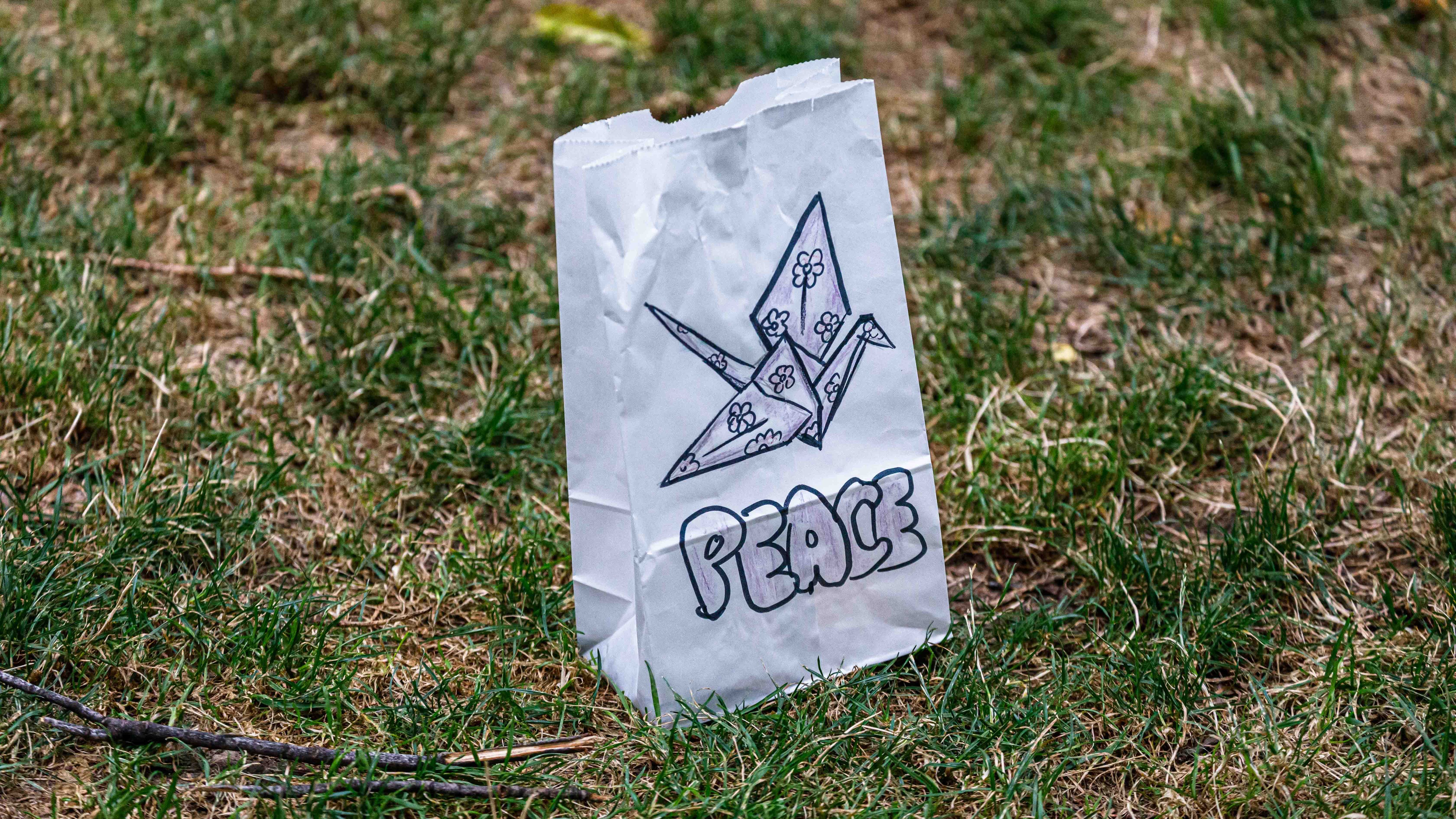 A white back with a drawing of a sandhill crane and puffy letters that spell out "peace."