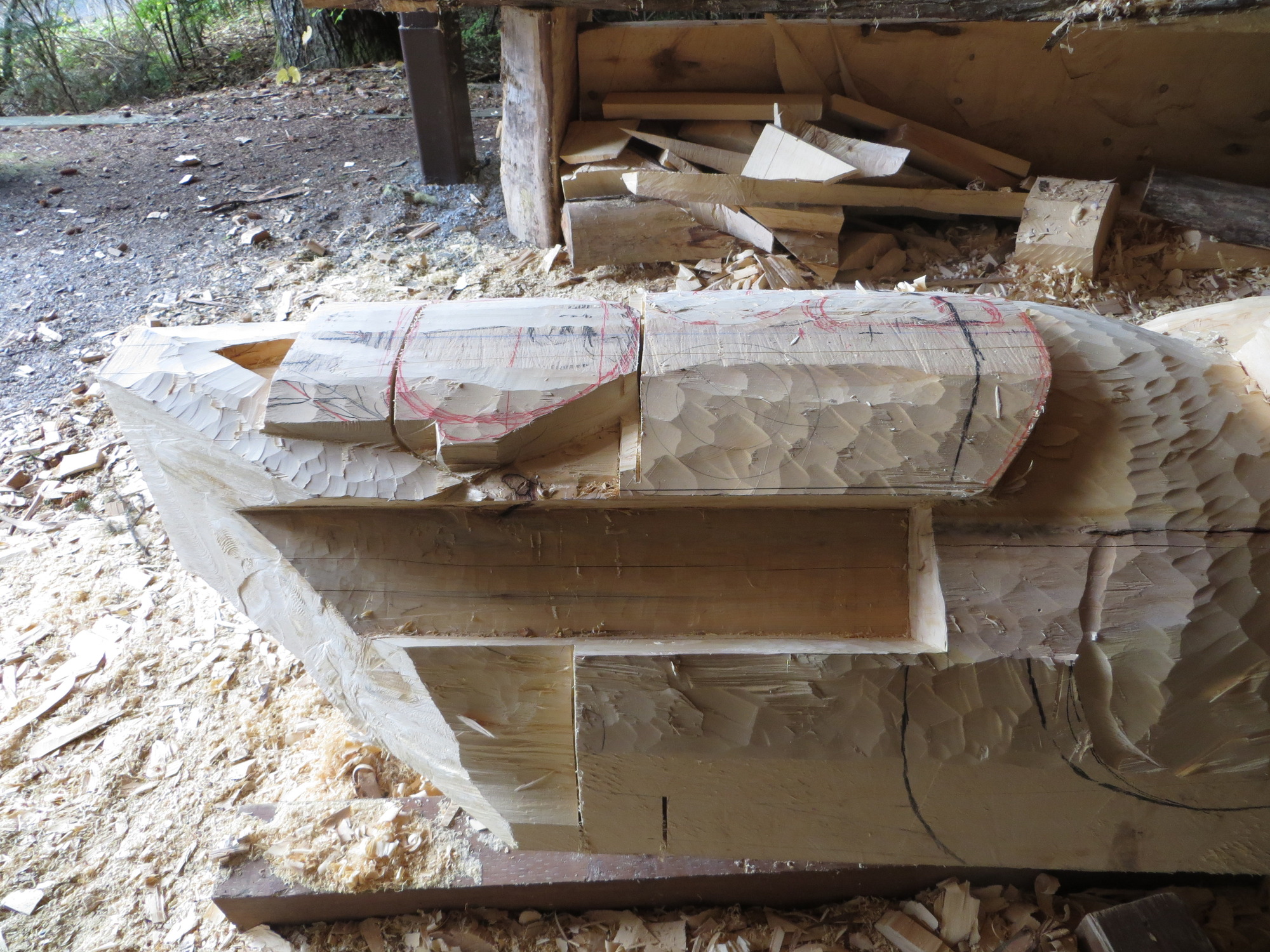 An undefined figure is chiseled into the top of the totem pole. 