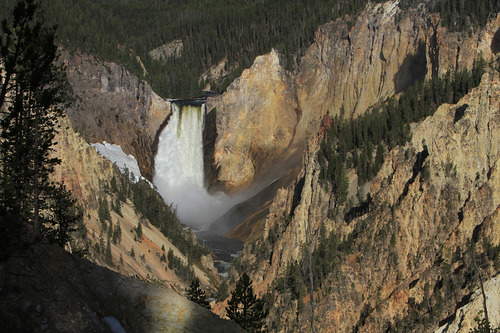 Water cascades over a distant ledge into a canyon