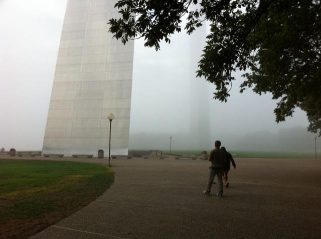 People walking on foggy Arch park grounds