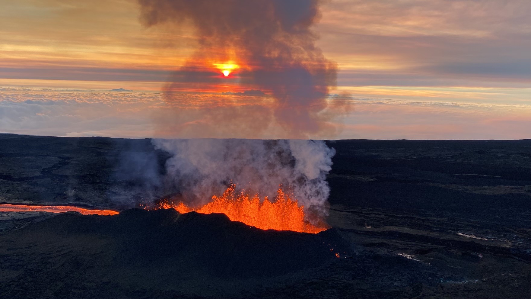Fountains of lava erupting from a fissure at sunrise.