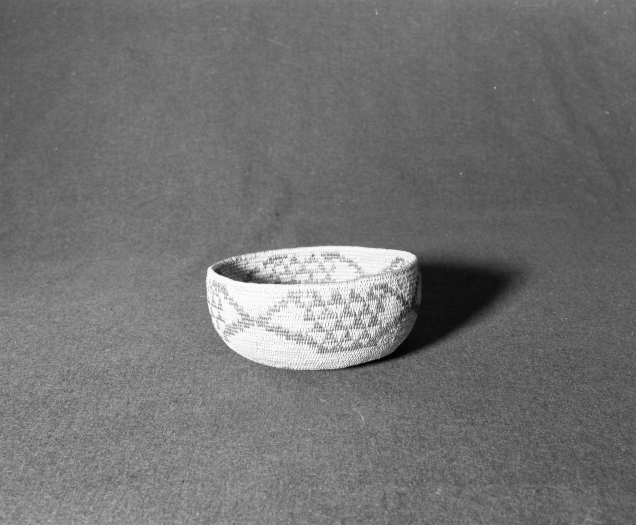 Marie Rozier Collection, Catalog No. 58. Object: Miwok basket. Dimensions: 8 x 3". Materials: split bull pine shoots, bracken fern root. Technology: single rod, usually split; leftward coil direction; fag ends trimmed on work face; moving ends clipped on interior. Collection History: storage basket bought from Evalene Cox Short by Miss Annie Teague ca. 1910. Photographed by Michael Dixon, December 1982. Catalogued by Craig Bates and Barbara Beroza. Yosemite Collections, National Park Service.