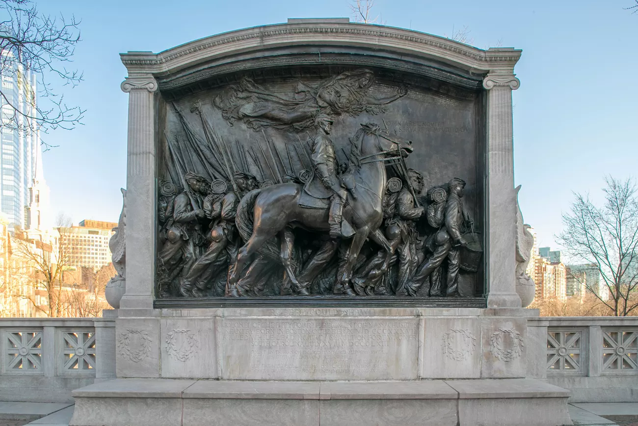 A stone memorial with bronze statue of soldiers marking and a commander on a horse.