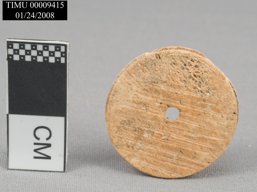 2 cm tall light brown button with a single button hole