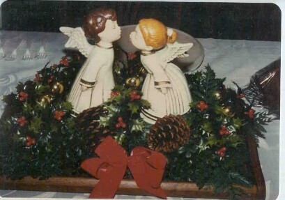 Centerpiece with two ceramic angels and greenery.