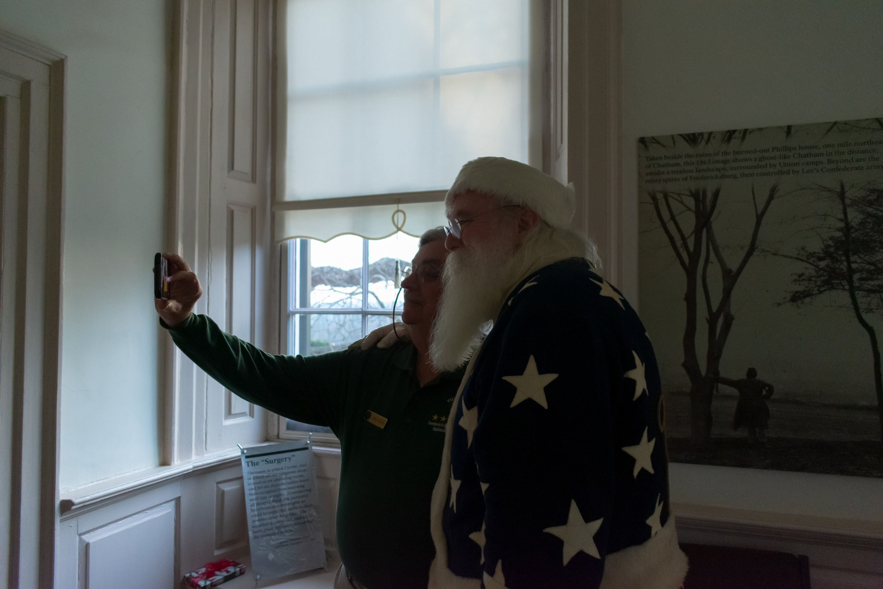 A volunteer takes a selfie with Santa.