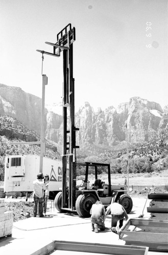 Workers operating a life machine during construction of headquarters addition.
