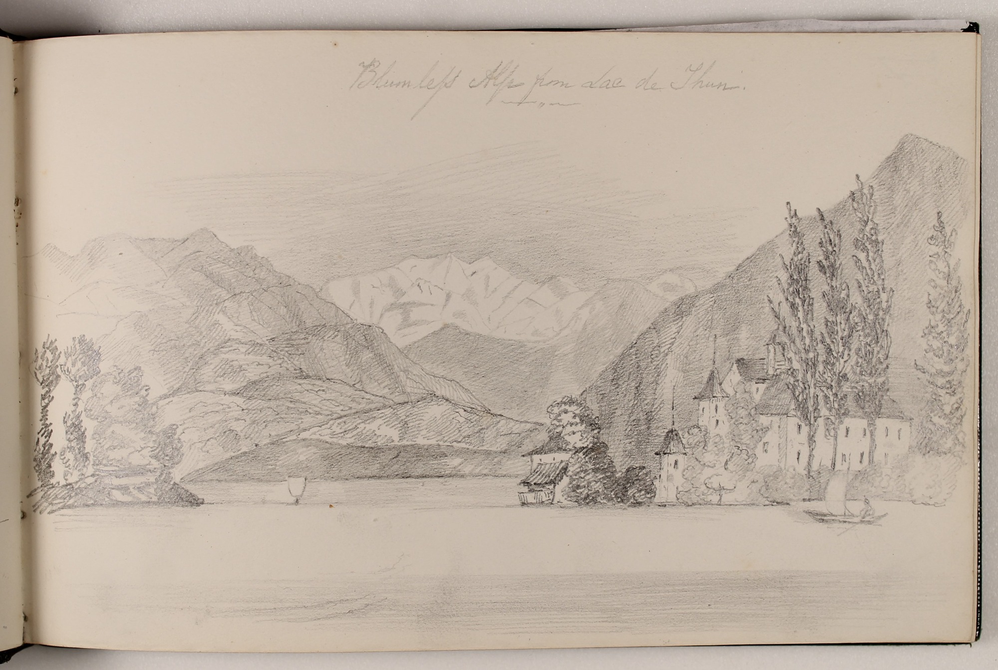 Pencil landscape in sketchbook of large mountains in distance with lake in foreground