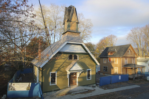 The church and parsonage at sunrise with construction work visible.