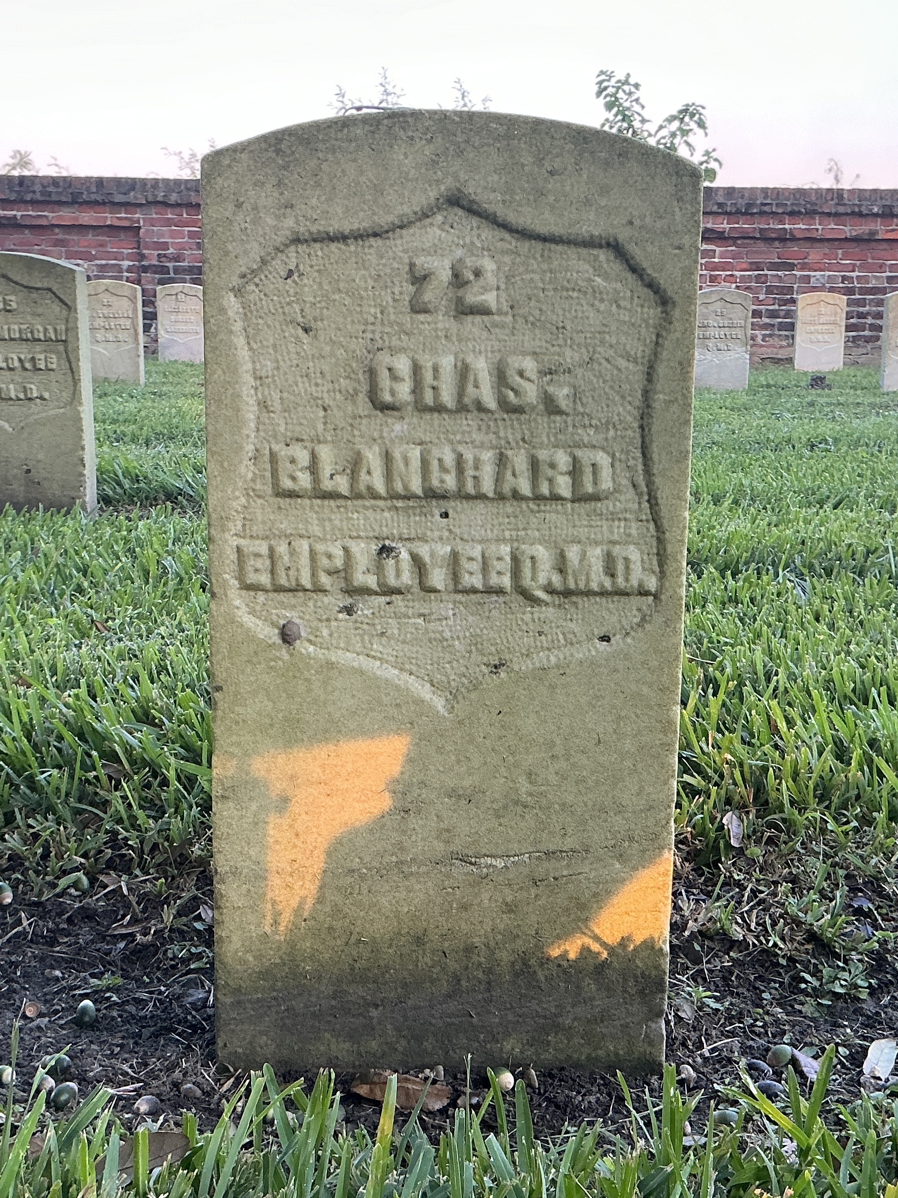 Front of historic upright marble headstone with recessed shield face.