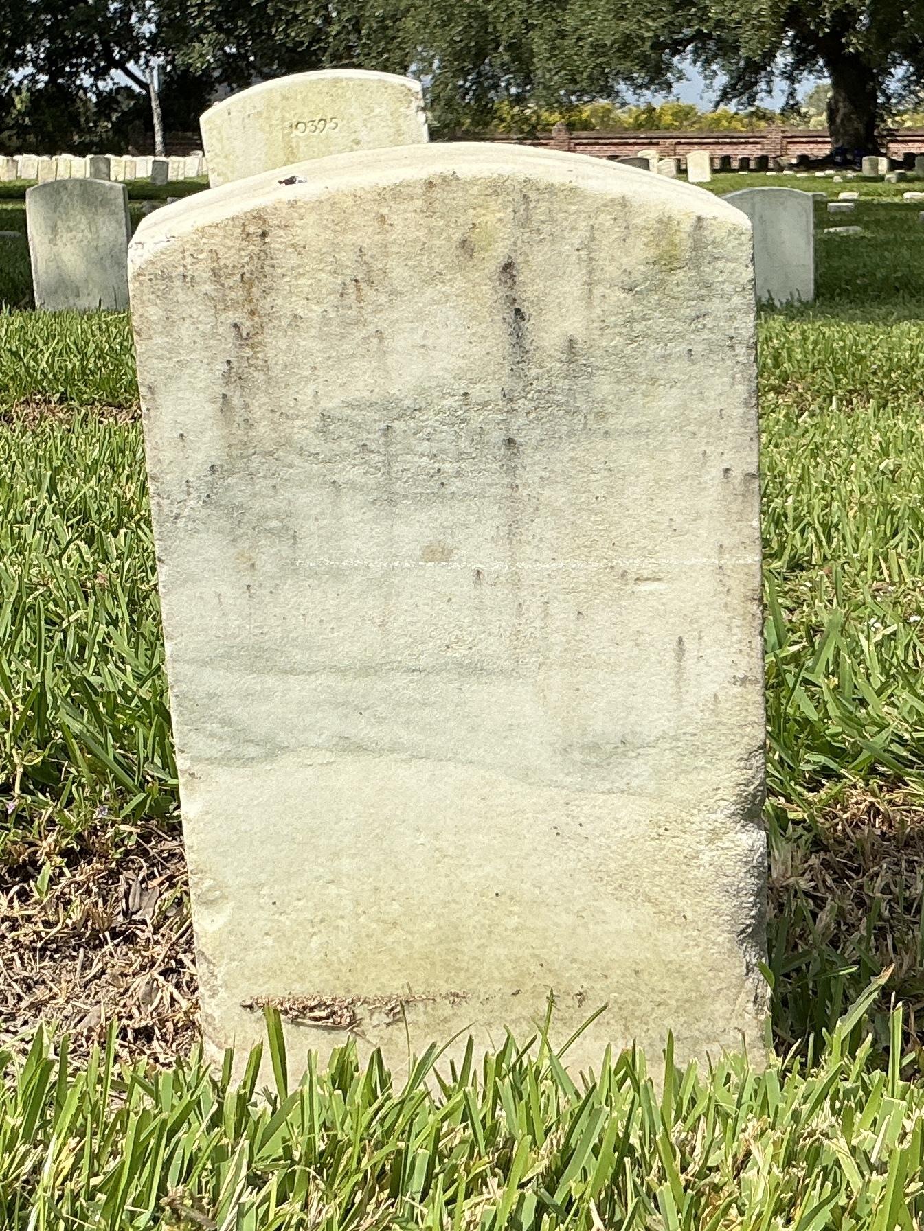Back of historic upright marble headstone with recessed shield with recessed lettering face.