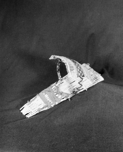 Marie Rozier Collection, Catalog No. 3-1. Object: Model Miwok cradle basket. Dimensions: 18 x 7". Materials: all willow, wool yarn, cotton cloth. Technology: up to right slant of turns; rude binding of top; maker was apparently uncertain how to finish top and stuffed it with excelsior material; hood attached by jammed bow rods through backboard, an "unusual" technique. Collection History: Made by Louise Fuentes for Mrs. Virgil Kimes. Photographed by Michael Dixon in December 1982. Catalogued by Craig Bates and Barbara Beroza. Yosemite Collections, National Park Service.