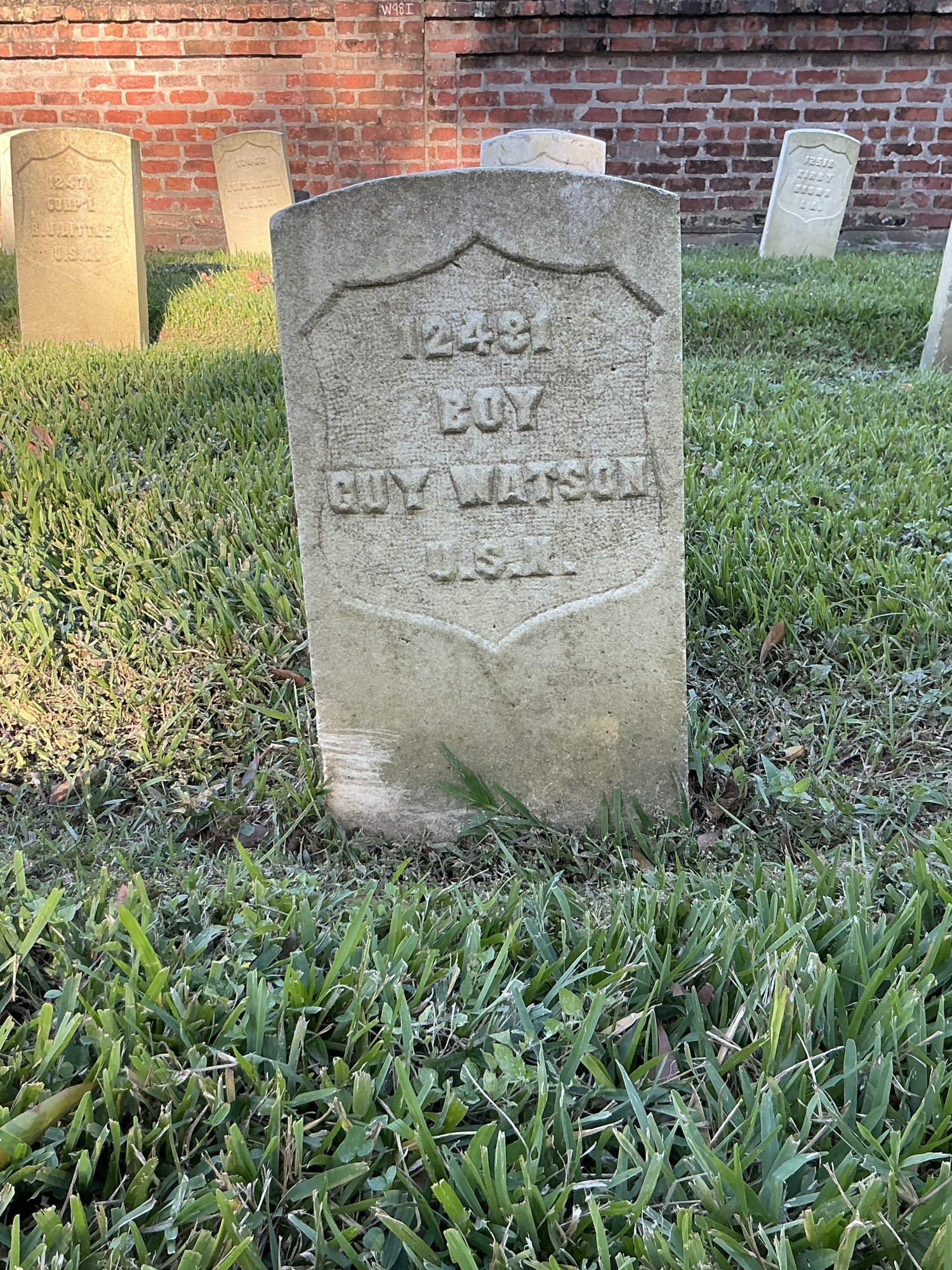 Front of historic upright marble headstone with recessed shield face.