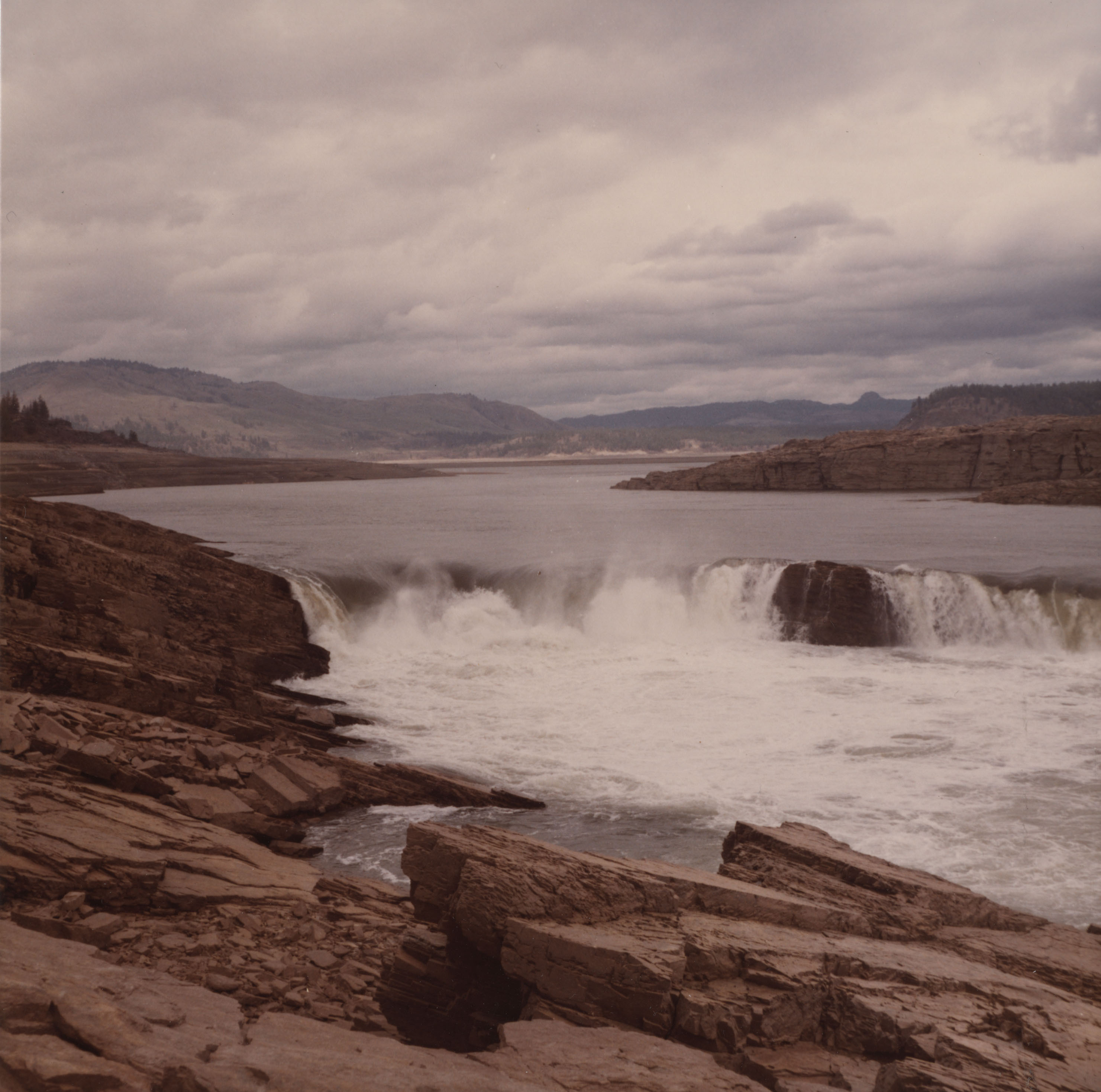 Color photograph of river rushing over exposed rock layers