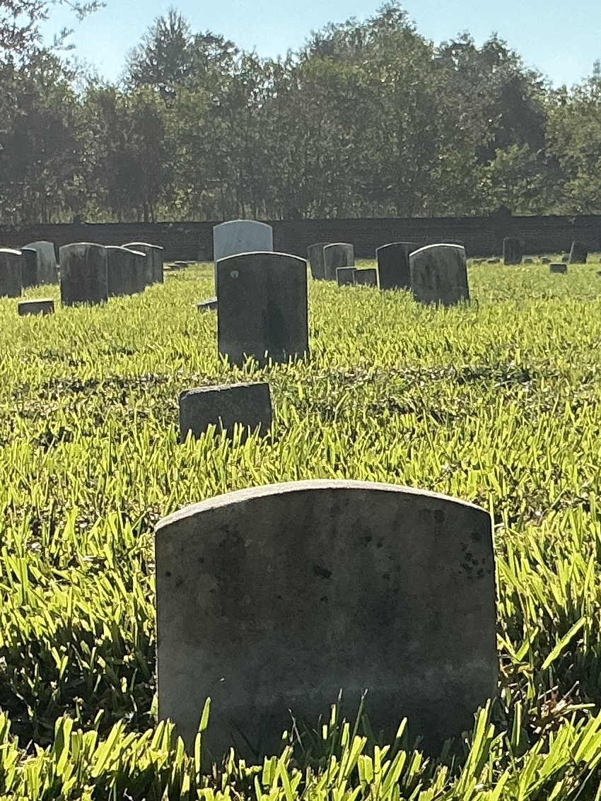 Back of historic upright marble headstone with recessed shield face.