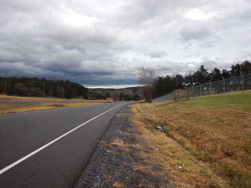 A national park entrance sign is mounted on the side of a divided two-lane highway.