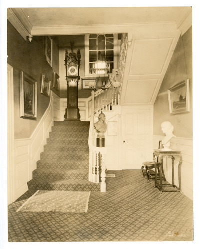 White stair case with a diamond patterned rung on the floors and stairs.