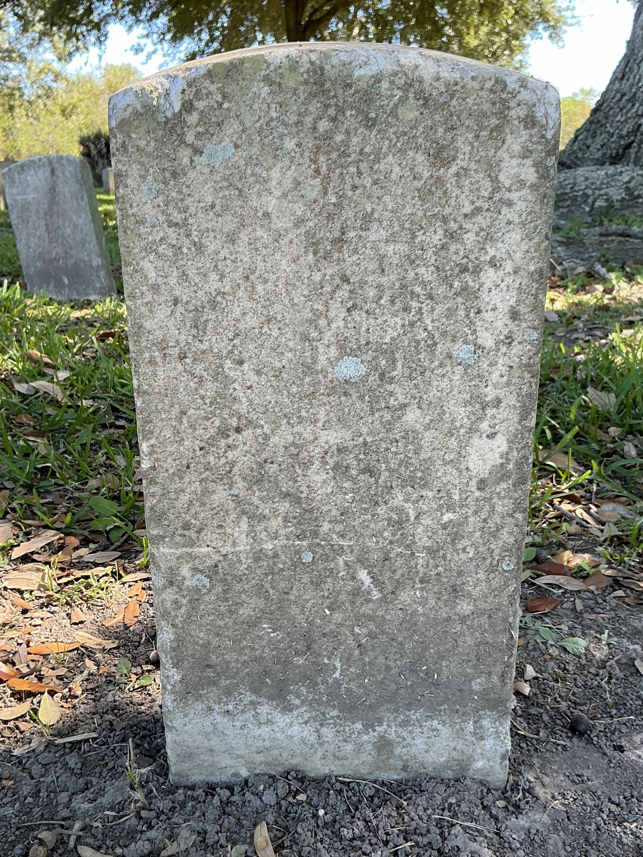 Back of historic upright marble headstone with recessed shield face.