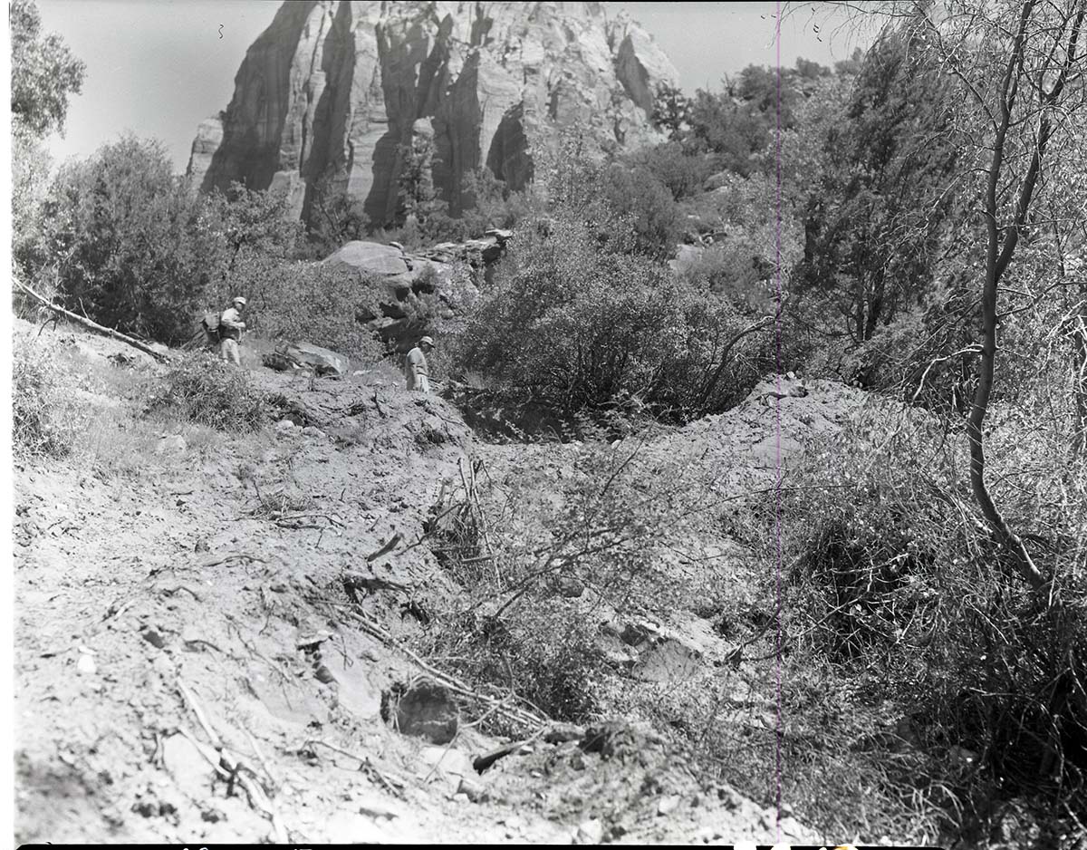 B. Mundy and N. Crawford walking on ridge above new spring intake - Springdale water system.