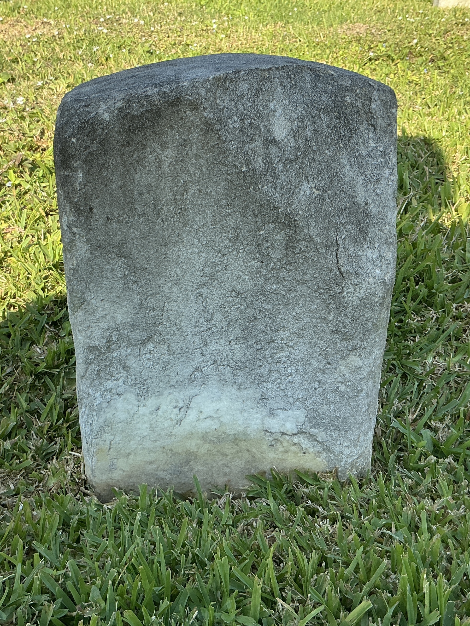 Back of historic upright marble headstone with recessed shield face.
