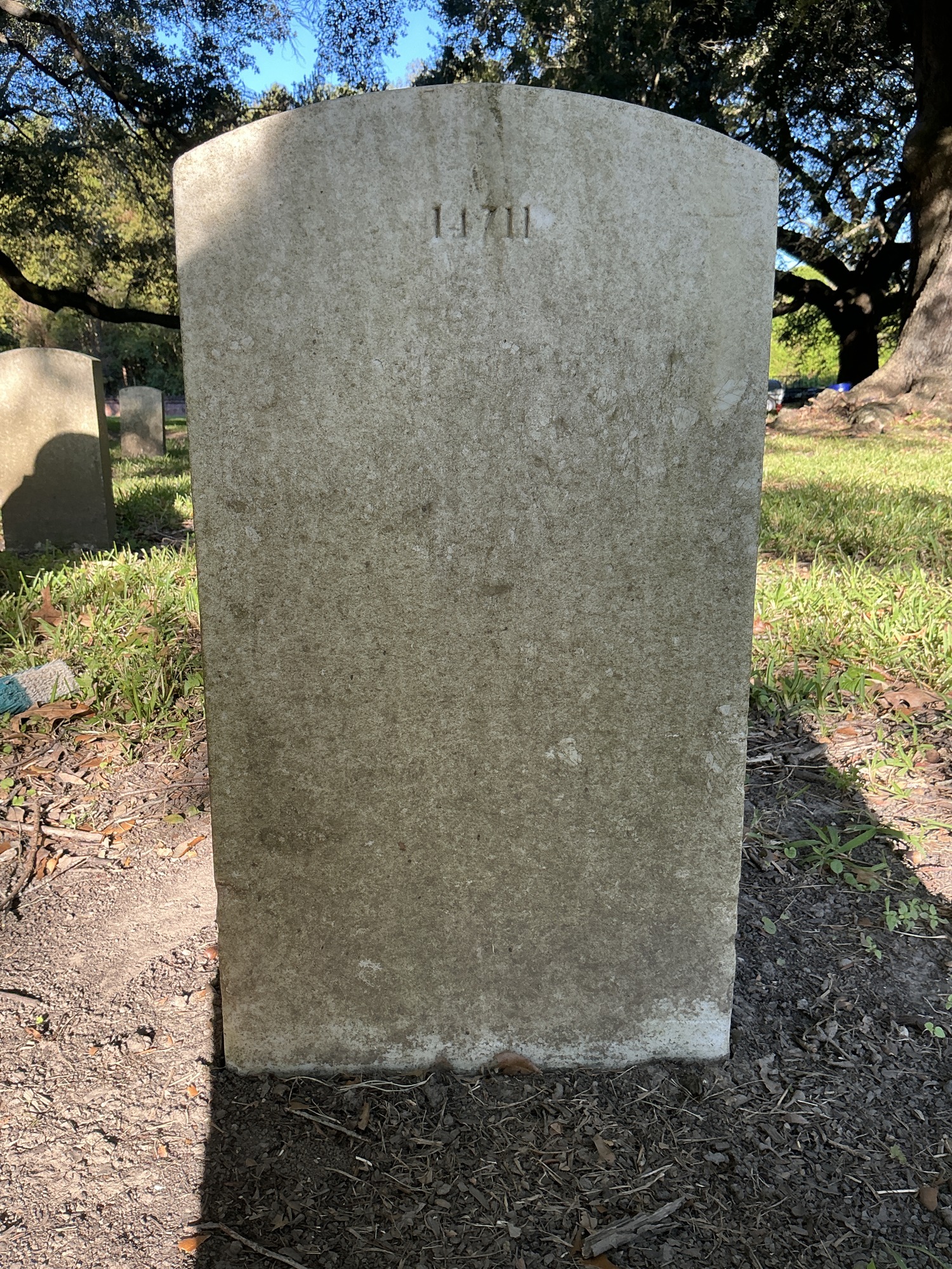 Back of upright marble headstone with flat face.