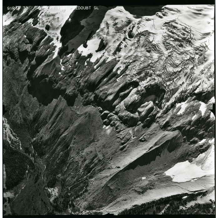 Black and white aerial photograph of glaciated mountain peaks and valleys.