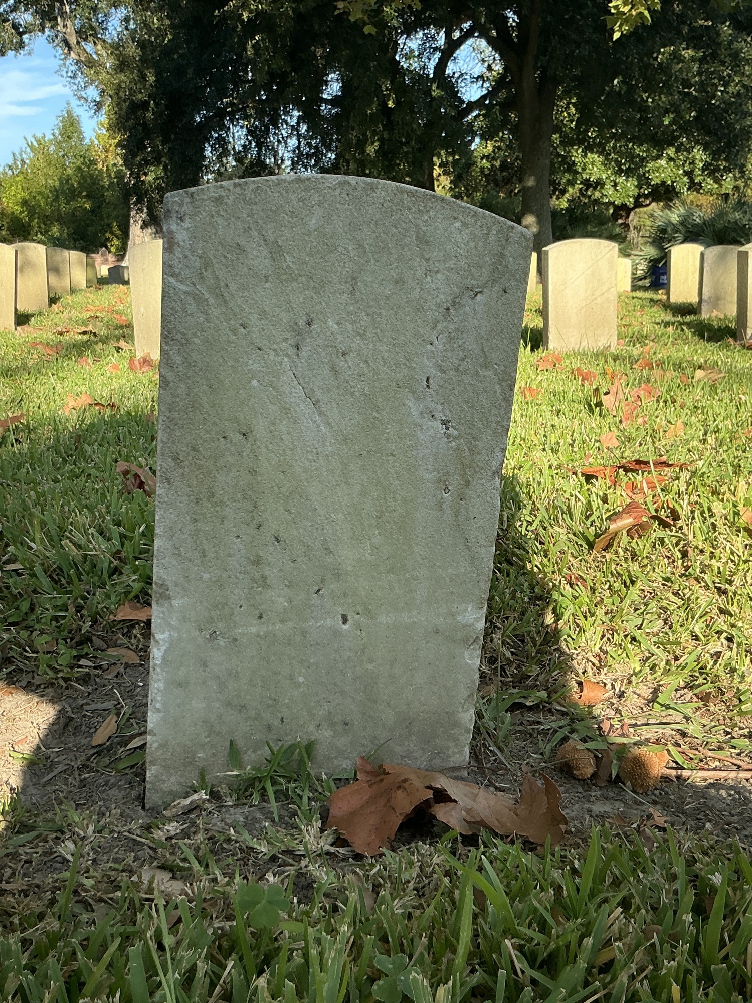 Back of historic upright marble headstone with recessed shield face.