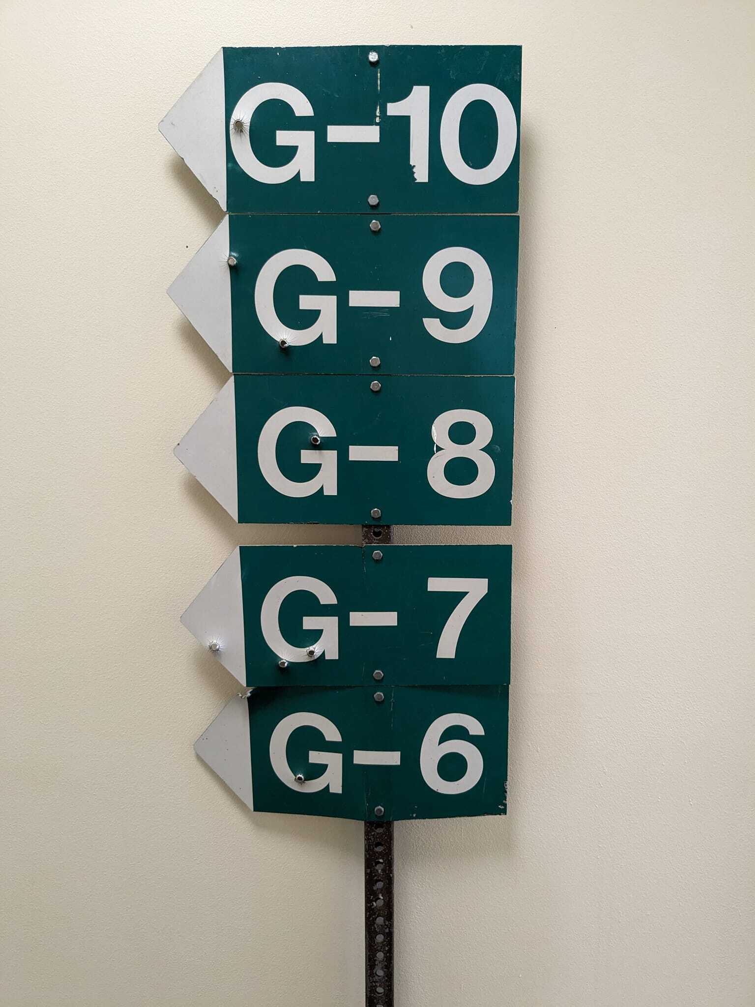 post with green road signs denoting the directions for locations G 6 through G 10