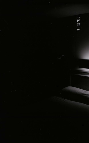 Bed and headboard in barracks. [Image possibly for comparative housing study]