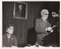 Charles Edison speaking into WNYC radio microphone. Madeleine Edison at left.