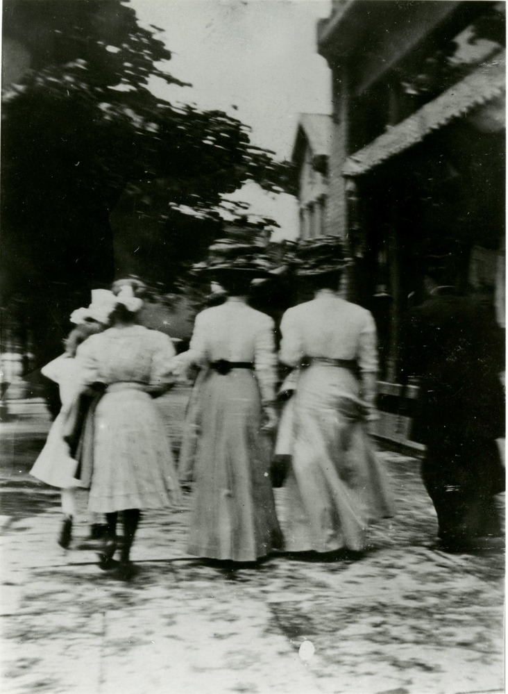 Three women walking away from camera