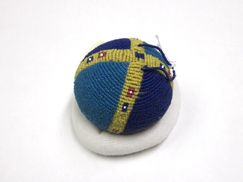 A game ball with blue, red, yellow and white beads.
