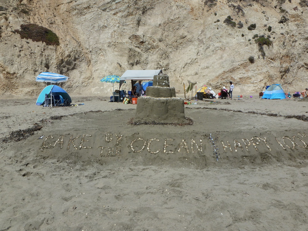 A large birthday cake made of sand commemorating the 100 year anniversary of the National Park Service.