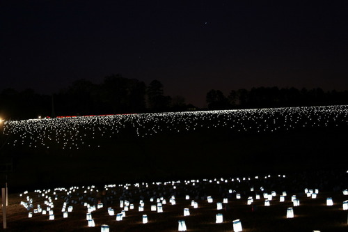 Candle luminaries illuminate the prison site