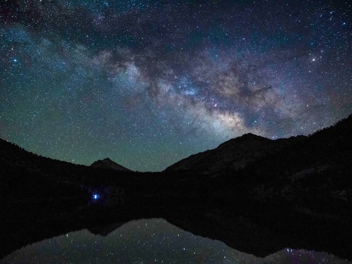 A starry sky over an alpine lake