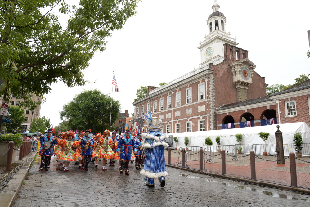 Mummers marching down Chestnut St, Independence Hall in background