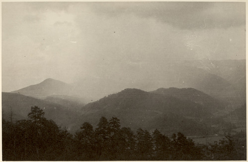 Historic photograph of rainstorm over distant mountain ridges.