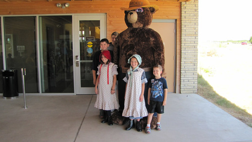 Kids pose with Smokey Bear