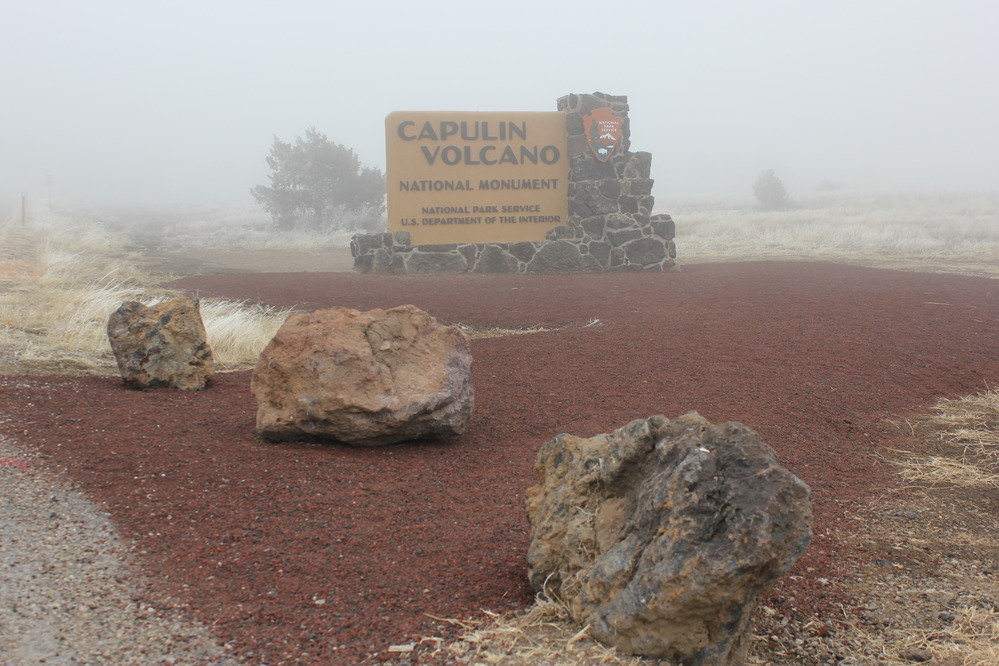 Park entrance sign beside entrance road.